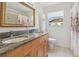 Bright bathroom features a double sink with granite countertop and ornate framed mirror at 18914 Geraci Rd, Lutz, FL 33548