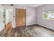 This bedroom features wood-look floors, light paint, a closet, and a window at 18914 Geraci Rd, Lutz, FL 33548