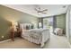 Well-lit bedroom with an elegant ceiling fan, slider, and stylish decor with green accent pillows at 18914 Geraci Rd, Lutz, FL 33548