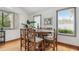 Bright dining room boasts wood floors and a round table with seating for six beneath natural light at 18914 Geraci Rd, Lutz, FL 33548
