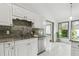 Well-lit kitchen featuring a stainless steel dishwasher and granite countertops at 18914 Geraci Rd, Lutz, FL 33548