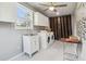 This clean laundry room has a modern washer, dryer, sink, cabinets, and mosaic accent wall at 18914 Geraci Rd, Lutz, FL 33548