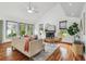 Bright living room featuring wood floors, fireplace, and large windows with natural light at 18914 Geraci Rd, Lutz, FL 33548