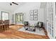 Sun-drenched living room features hardwood floors, vaulted ceiling, seating area, and access to bonus space at 18914 Geraci Rd, Lutz, FL 33548