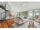 Open living room featuring a spiral staircase, hardwood floors, and natural light at 18914 Geraci Rd, Lutz, FL 33548