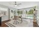 Sun-filled office boasts hardwood floors, modern desk, chair, and view of pool area at 18914 Geraci Rd, Lutz, FL 33548