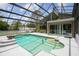 Screened-in pool with steps and white concrete surround, connected to a green house with a spiral staircase at 18914 Geraci Rd, Lutz, FL 33548