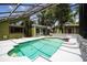 Screened-in pool with white concrete surround and a connected green house at 18914 Geraci Rd, Lutz, FL 33548
