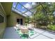 Screened-in porch with outdoor furniture and a green leaf printed rug at 18914 Geraci Rd, Lutz, FL 33548
