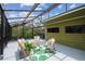 A view of the outdoor screened in porch with a green exterior and a view at 18914 Geraci Rd, Lutz, FL 33548