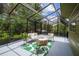 A view of a screened in porch with an outdoor seating area at 18914 Geraci Rd, Lutz, FL 33548