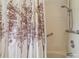 Shower area with neutral tile and a shower curtain with a nature scene at 18914 Geraci Rd, Lutz, FL 33548