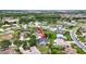 Aerial view of a home in a lushly landscaped community, marked with a red arrow at 205 Wimbly Pl, Sun City Center, FL 33573