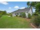 Spacious backyard with lush green grass, mature plantings and blue sky at 205 Wimbly Pl, Sun City Center, FL 33573