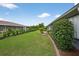 Green backyard featuring grass, neatly trimmed shrubbery and a privacy hedge at 205 Wimbly Pl, Sun City Center, FL 33573