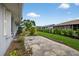 Concrete driveway, side of home, trimmed shrubbery, and green grass at 205 Wimbly Pl, Sun City Center, FL 33573