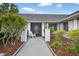 Welcoming home entrance featuring a serene sitting area and enhanced by beautifully maintained landscaping at 205 Wimbly Pl, Sun City Center, FL 33573