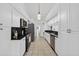 Bright kitchen with white cabinets, stainless steel appliances and black countertops at 205 Wimbly Pl, Sun City Center, FL 33573