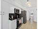 Bright kitchen with white cabinets, stainless steel appliances and black countertops at 205 Wimbly Pl, Sun City Center, FL 33573