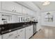 Well-lit kitchen features dark countertops, white cabinets, and a seamless transition to the living area at 205 Wimbly Pl, Sun City Center, FL 33573