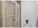 Shower stall featuring decorative earth-toned tiles, a glass door, and white toilet at 205 Wimbly Pl, Sun City Center, FL 33573