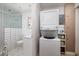 Modern bathroom featuring a shower, stacked washer/dryer unit, and clean, white tile at 2135 Pocahontas Dr, Largo, FL 33774
