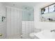 Bathroom with walk-in shower, glass partition, white tiled walls, and modern fixtures at 2135 Pocahontas Dr, Largo, FL 33774