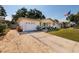 Charming single-story home featuring a well-maintained lawn, driveway, and garage at 2135 Pocahontas Dr, Largo, FL 33774