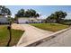 Charming single-story home featuring a well-maintained lawn, mature trees, and a long driveway leading to a one-car garage at 2135 Pocahontas Dr, Largo, FL 33774