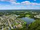 Expansive community aerial view with lake, lush greenery, and blue skies at 21395 Southern Charm Dr, Land O Lakes, FL 34637
