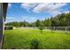 Well-maintained backyard with lush green grass, a white fence and trees in the background at 21395 Southern Charm Dr, Land O Lakes, FL 34637