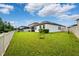 Expansive backyard with well-kept lawn, white picket fence, and view of the home's exterior at 21395 Southern Charm Dr, Land O Lakes, FL 34637