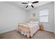 Bright bedroom with neutral walls and carpet features a ceiling fan and a double window at 21395 Southern Charm Dr, Land O Lakes, FL 34637