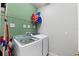 Functional laundry room with modern washer and dryer, shelving and neutral color scheme at 21395 Southern Charm Dr, Land O Lakes, FL 34637