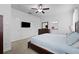 Bright main bedroom showcases neutral walls, carpet, a ceiling fan, and a large flat-screen television at 21395 Southern Charm Dr, Land O Lakes, FL 34637