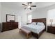 Bright main bedroom features a decorative headboard, ceiling fan, ensuite bathroom, and a coordinating dresser at 21395 Southern Charm Dr, Land O Lakes, FL 34637