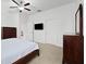 Bright main bedroom showcases neutral walls, carpet, a ceiling fan, and a large flat-screen television at 21395 Southern Charm Dr, Land O Lakes, FL 34637