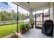 Relaxing screened patio featuring tropical plants, black screen frame and view of fenced backyard at 21395 Southern Charm Dr, Land O Lakes, FL 34637