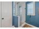 A walk-in shower features a glass door and white subway tiles in the blue-walled bathroom at 2388 Oakwood Preserve Dr, Wesley Chapel, FL 33543