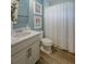 Cozy bathroom with modern vanity, framed art, and a white patterned shower curtain at 2388 Oakwood Preserve Dr, Wesley Chapel, FL 33543