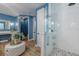A modern blue bathroom showcases a walk-in shower and sleek vanity area at 2388 Oakwood Preserve Dr, Wesley Chapel, FL 33543