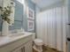 Cozy bathroom with modern vanity, framed art, and a white patterned shower curtain at 2388 Oakwood Preserve Dr, Wesley Chapel, FL 33543