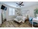 Cozy bedroom features light walls, wood floors, shuttered window, and a comfortable bed with decorative pillows at 2388 Oakwood Preserve Dr, Wesley Chapel, FL 33543