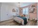 Charming bedroom features a unique chandelier, accent wall, floating shelves and lots of natural light at 2388 Oakwood Preserve Dr, Wesley Chapel, FL 33543