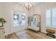 Bright entryway with a glass double door, chandelier, large mirror, bench, and hardwood floors at 2388 Oakwood Preserve Dr, Wesley Chapel, FL 33543