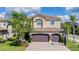 Two-story home featuring a three-car garage, paver driveway, neutral stucco, and manicured landscaping at 2388 Oakwood Preserve Dr, Wesley Chapel, FL 33543
