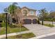 Two-story home featuring a three-car garage, paver driveway, neutral stucco, and manicured landscaping at 2388 Oakwood Preserve Dr, Wesley Chapel, FL 33543