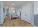 Hallway with wood floors, a round mirror and a bench at 2388 Oakwood Preserve Dr, Wesley Chapel, FL 33543