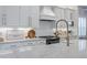 Modern kitchen featuring white cabinets, marble countertops, and stainless-steel appliances at 2388 Oakwood Preserve Dr, Wesley Chapel, FL 33543
