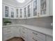 Bright kitchen featuring white cabinets with glass fronts and gold hardware and light countertops at 2388 Oakwood Preserve Dr, Wesley Chapel, FL 33543
